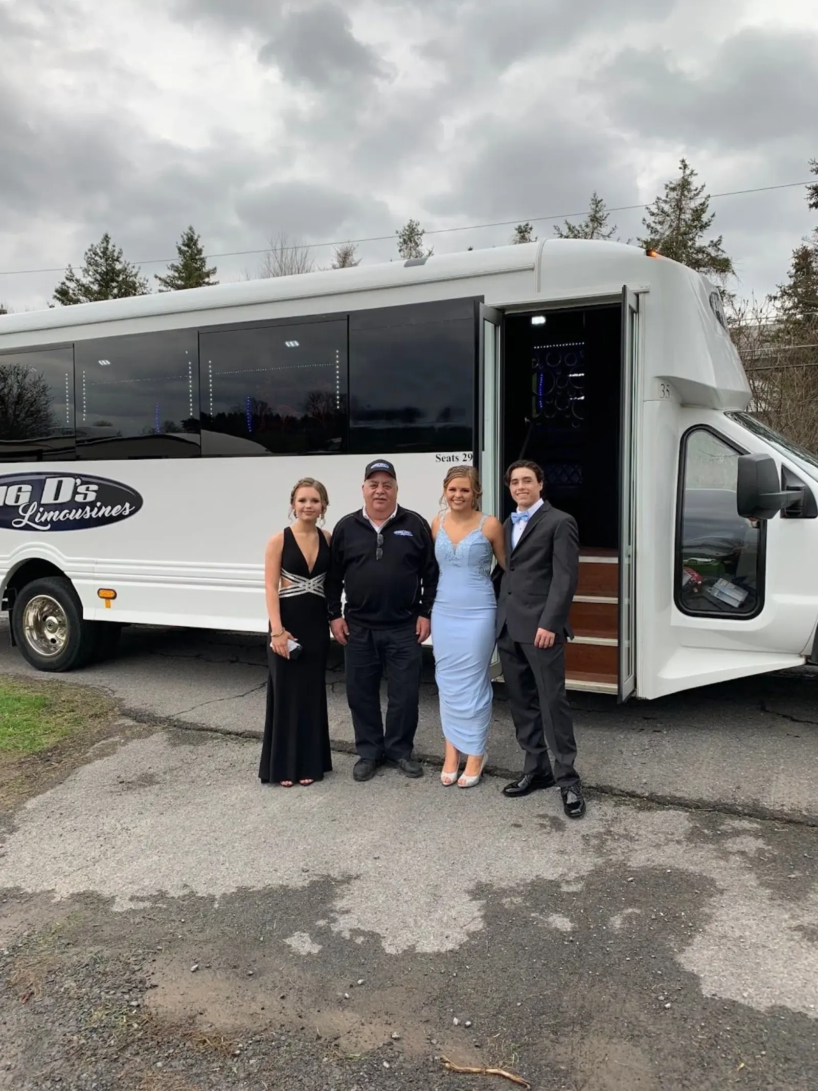 Students in formalwear boarding a limousine