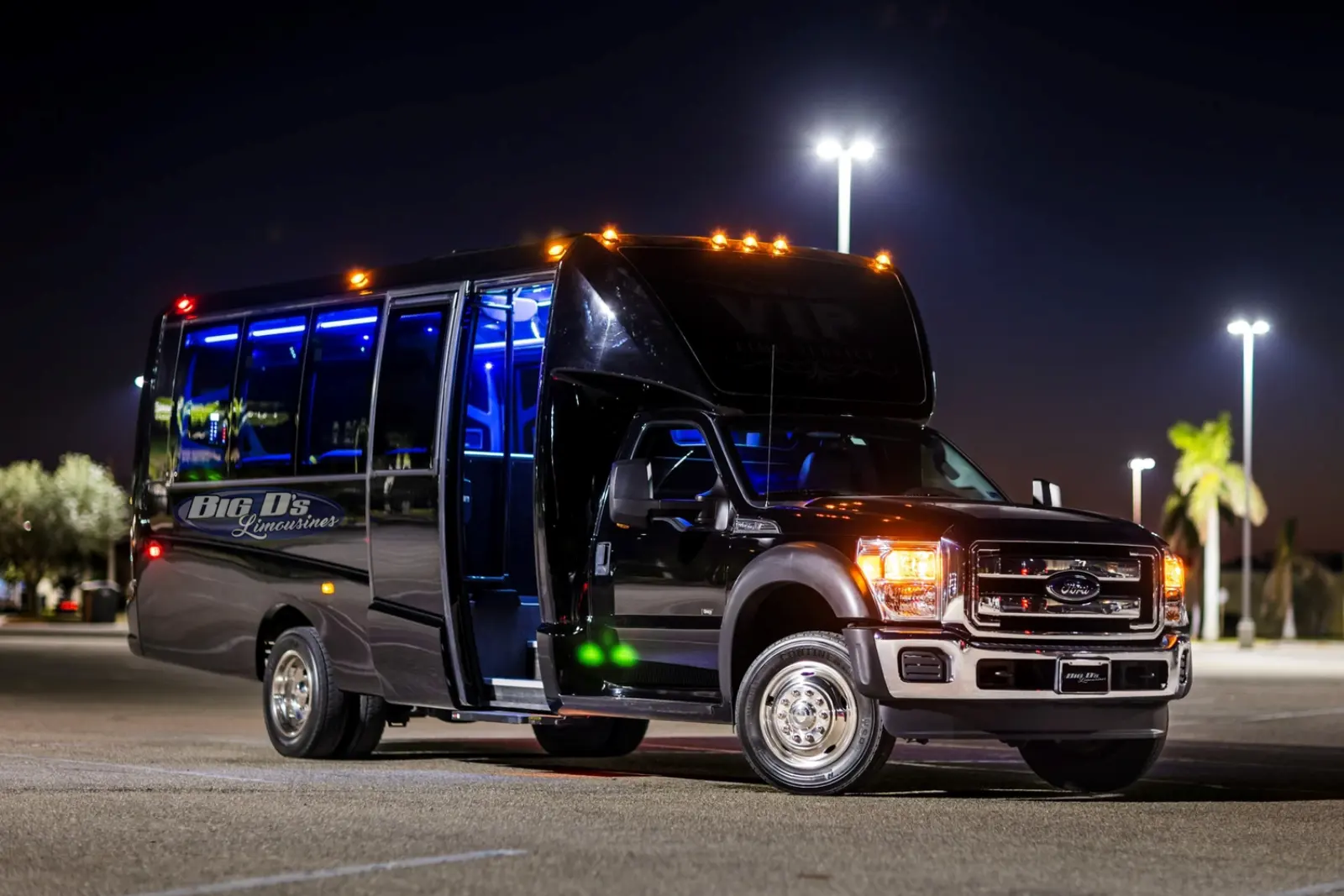 A Big D's coach at night with its door open and interior lighting on