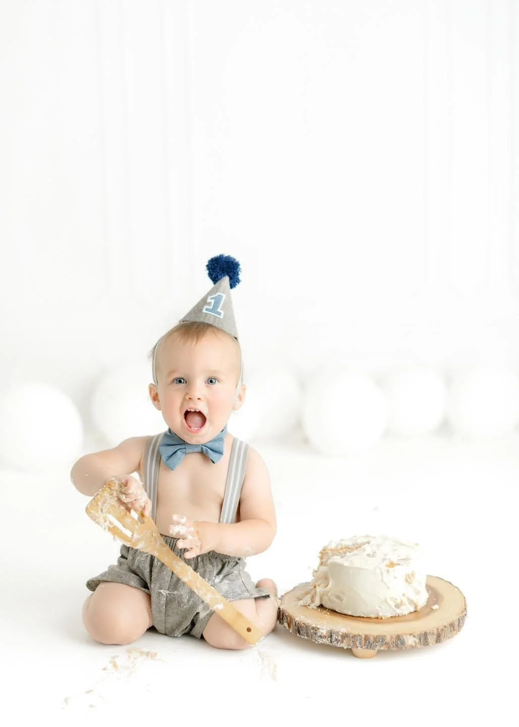 Baby exploring their first birthday cake in-studio