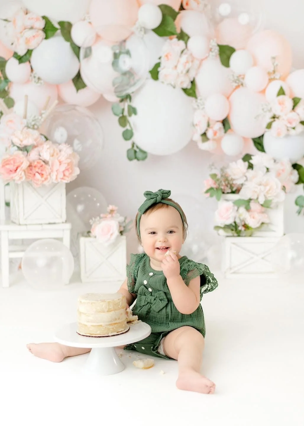 Baby exploring their first birthday cake in-studio