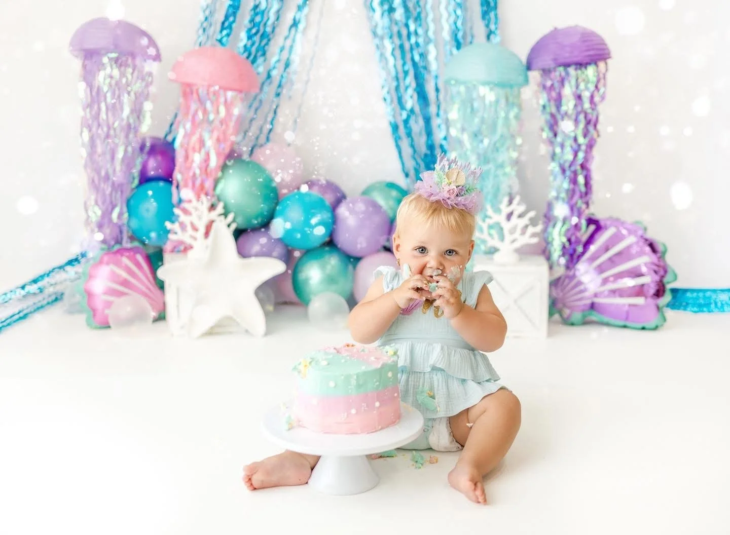 Baby exploring their first birthday cake in-studio