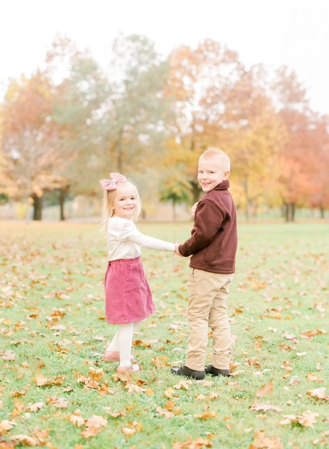 Two young siblings laughing together during an autumn family session in Central New York