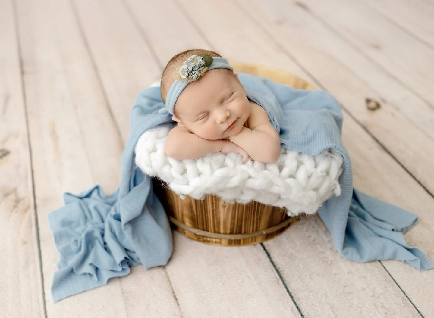 Sleeping newborn posed in a basket during a Syracuse newborn session